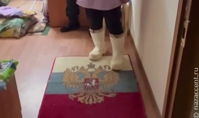 Мигрантку, вытиравшую ноги о коврик с изображением флага РФ, вышлют из страны
